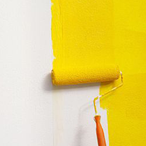 Yellow paint roller painting wall